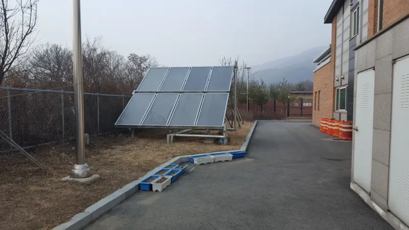 태양열 집열설비 참고 사진(공기식 온풍기 확인 안 됨) · 건물 옆 지상에 설치된 평판형 태양열 집열기