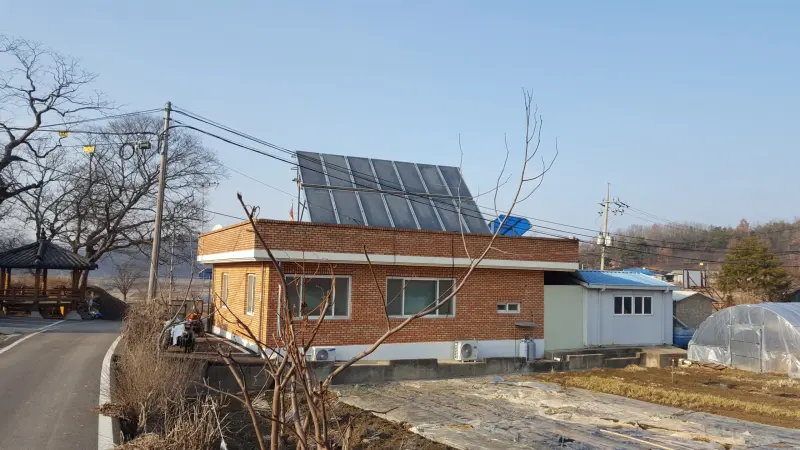 단층 건물 지붕 위에 설치된 평판형 태양열 집열기